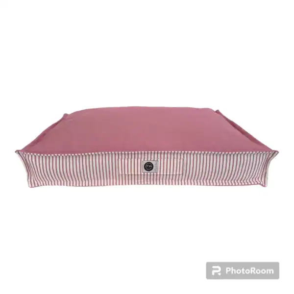 Alfombra para mascotas color rosa con borde a rayas blancas y rojas.