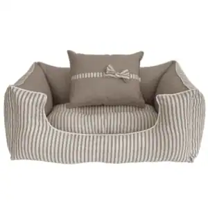 Sueño para mascotas en tonos neutros con cojín decorativo en rayas.