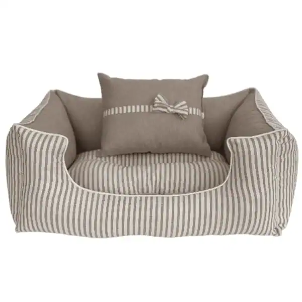 Sueño para mascotas en tonos neutros con cojín decorativo en rayas.