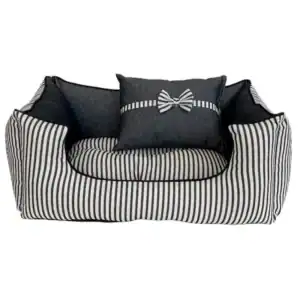 Alto texto: Sofá cama de diseño en rayas negras y blancas con cojines decorativos.