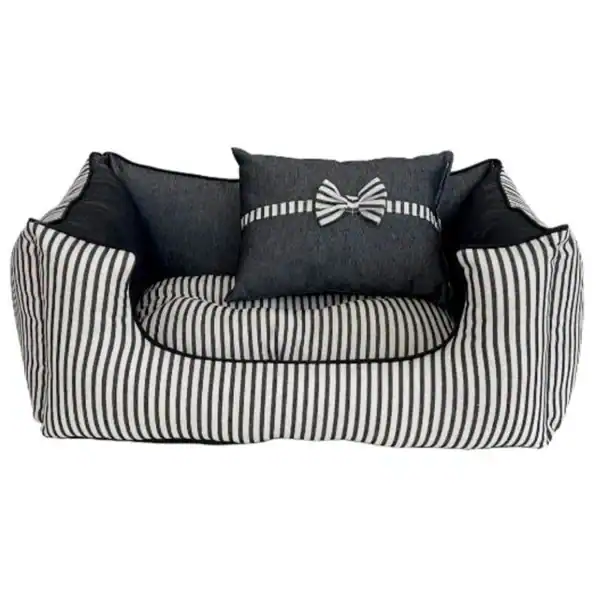 Alto texto: Sofá cama de diseño en rayas negras y blancas con cojines decorativos.