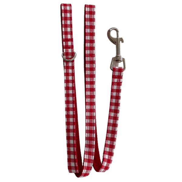 Correa para mascotas en tela de cuadros rojos y blancos con gancho metálico y ojal en anillo de metal.