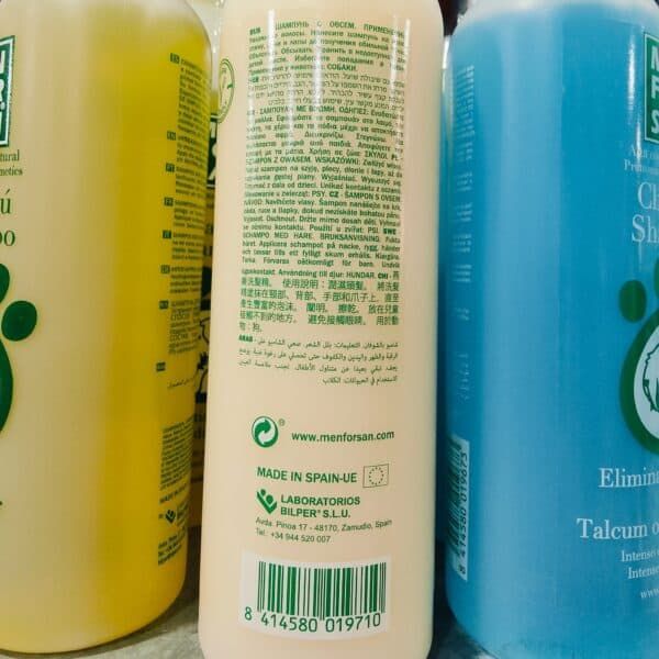 Limpiador de cabello en botella blanca con etiquetas en diversos idiomas y código de barras.