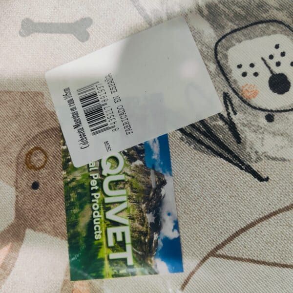 Imagen de etiqueta de producto con logotipo y paisaje de montaña, fondo de tela con dibujo de perro.