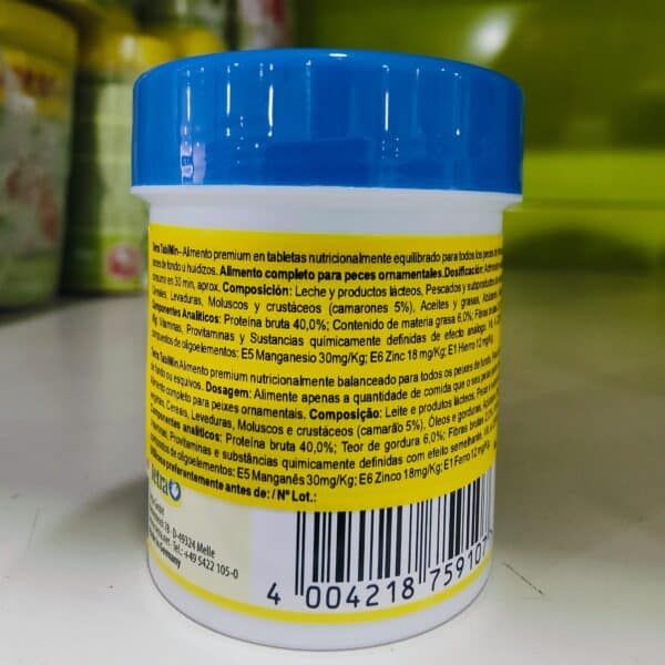 Alto texto: Envase de suplemento nutricional para peces ornamentales con ingredientes naturales y análisis de componentes.
