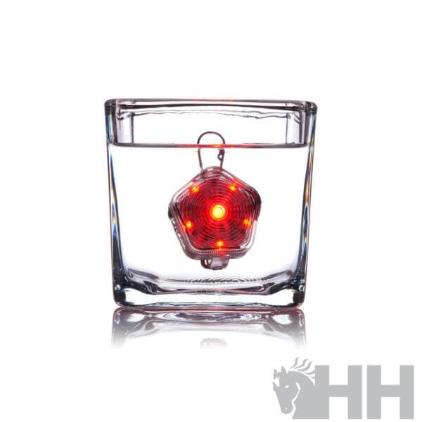 Luz de advertencia LED sumergida en vaso de agua para seguridad.